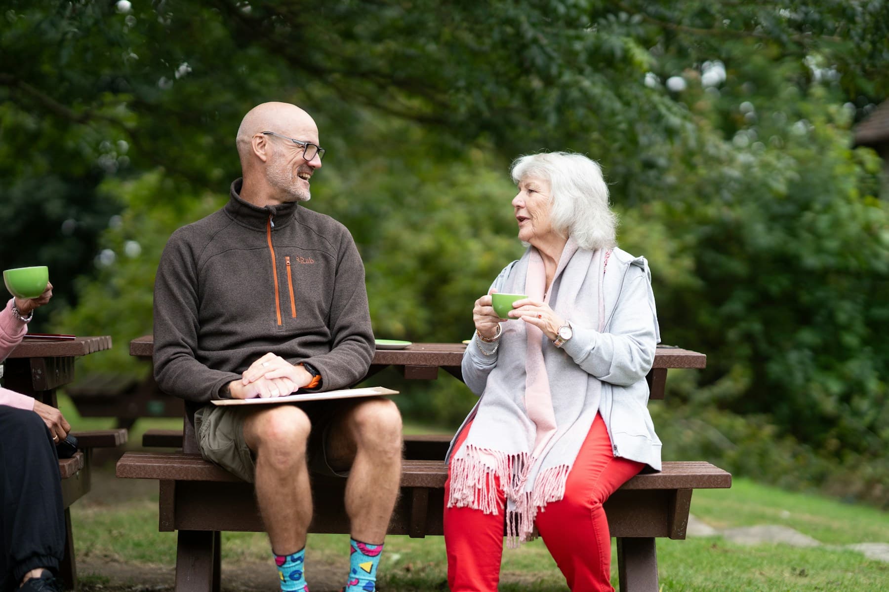 An older man and woman sitting together on a park bench