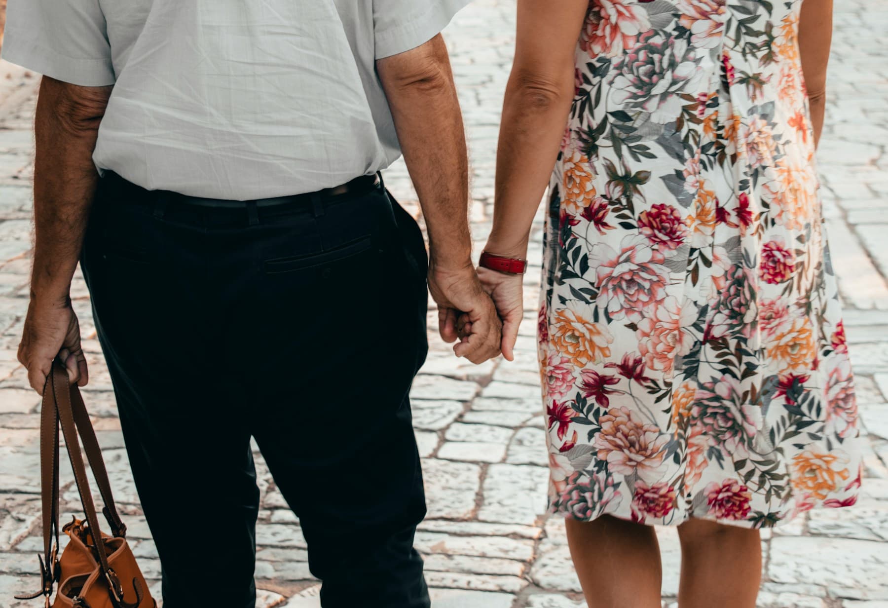 A close-up of an older couple holding hands