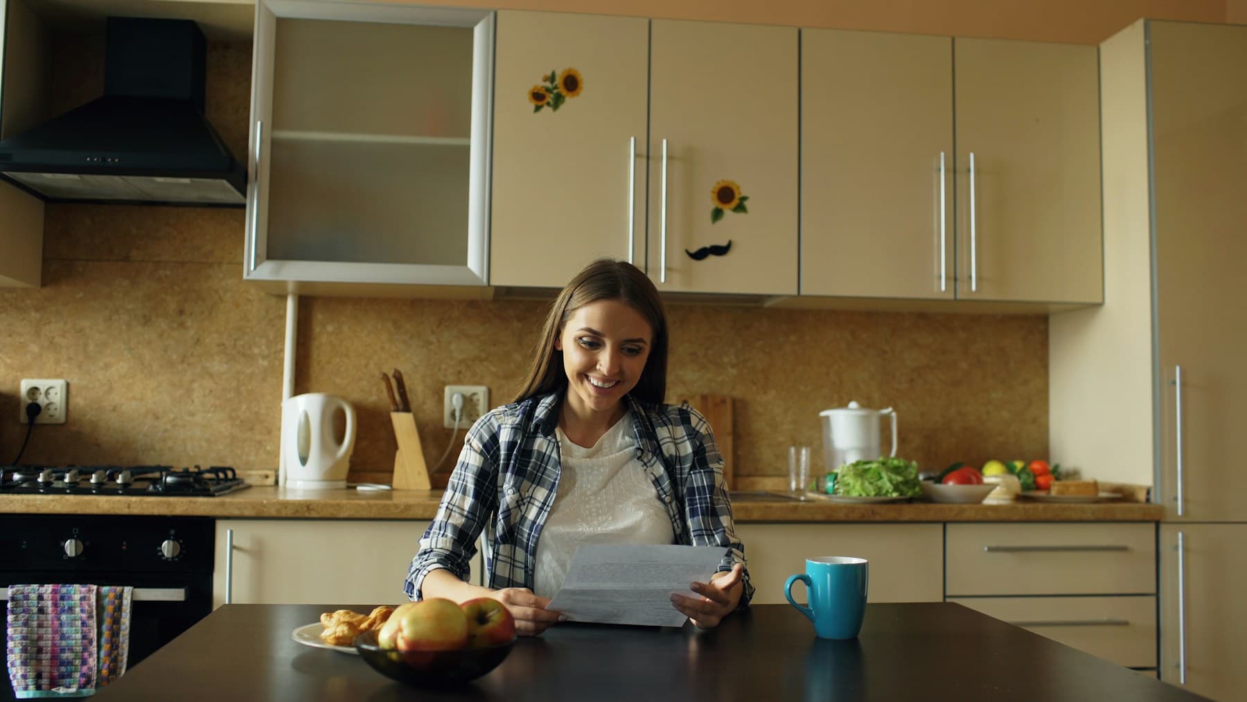 A woman reading a document at her kitchen table with a cup of coffee