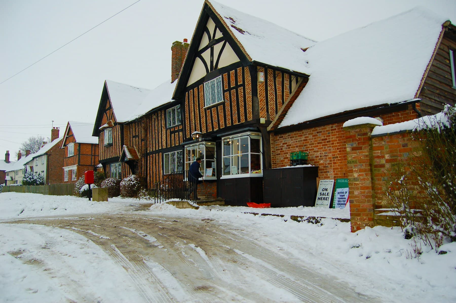 A snow-covered residential street in front of a house