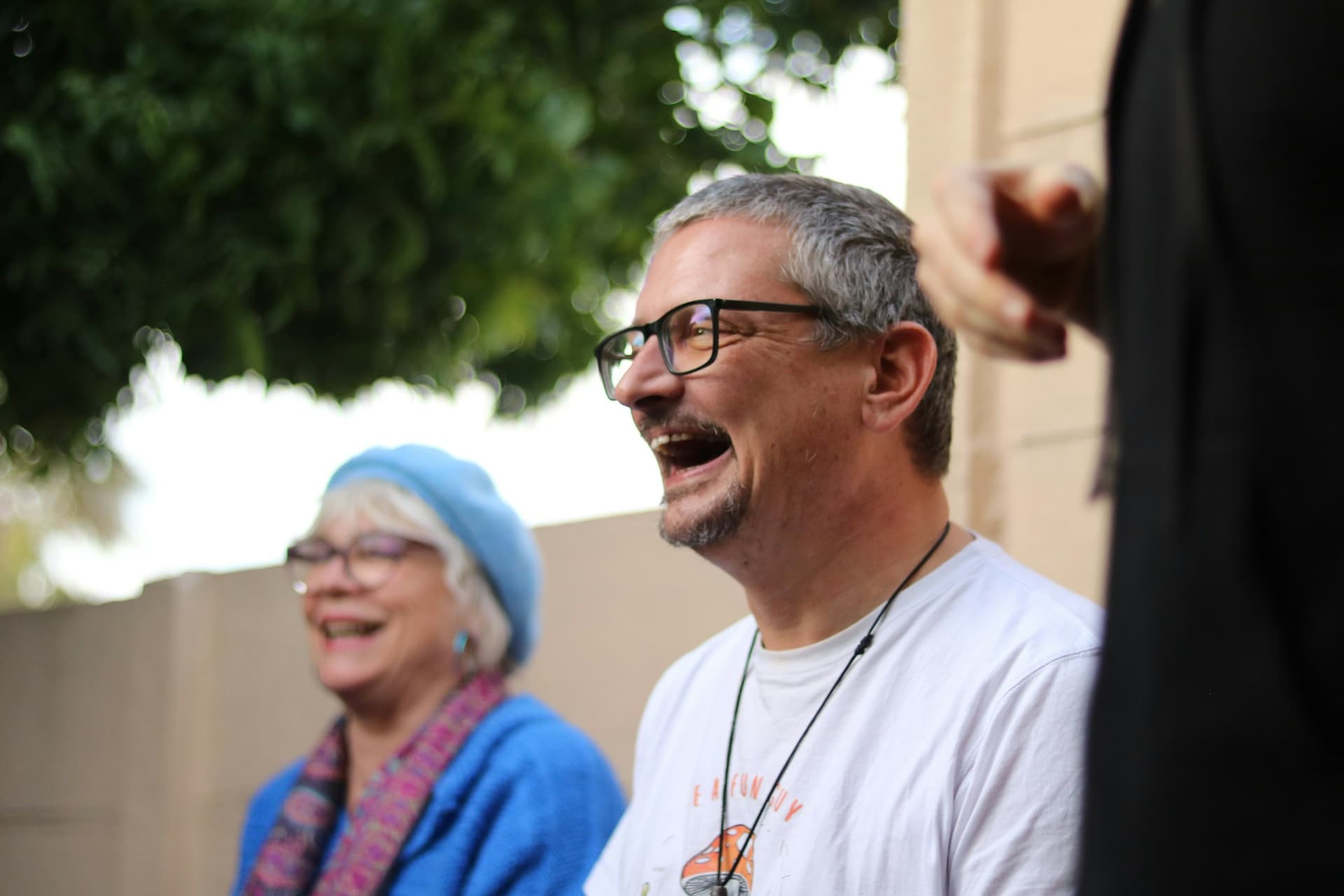 A man and a woman laughing together outdoors
