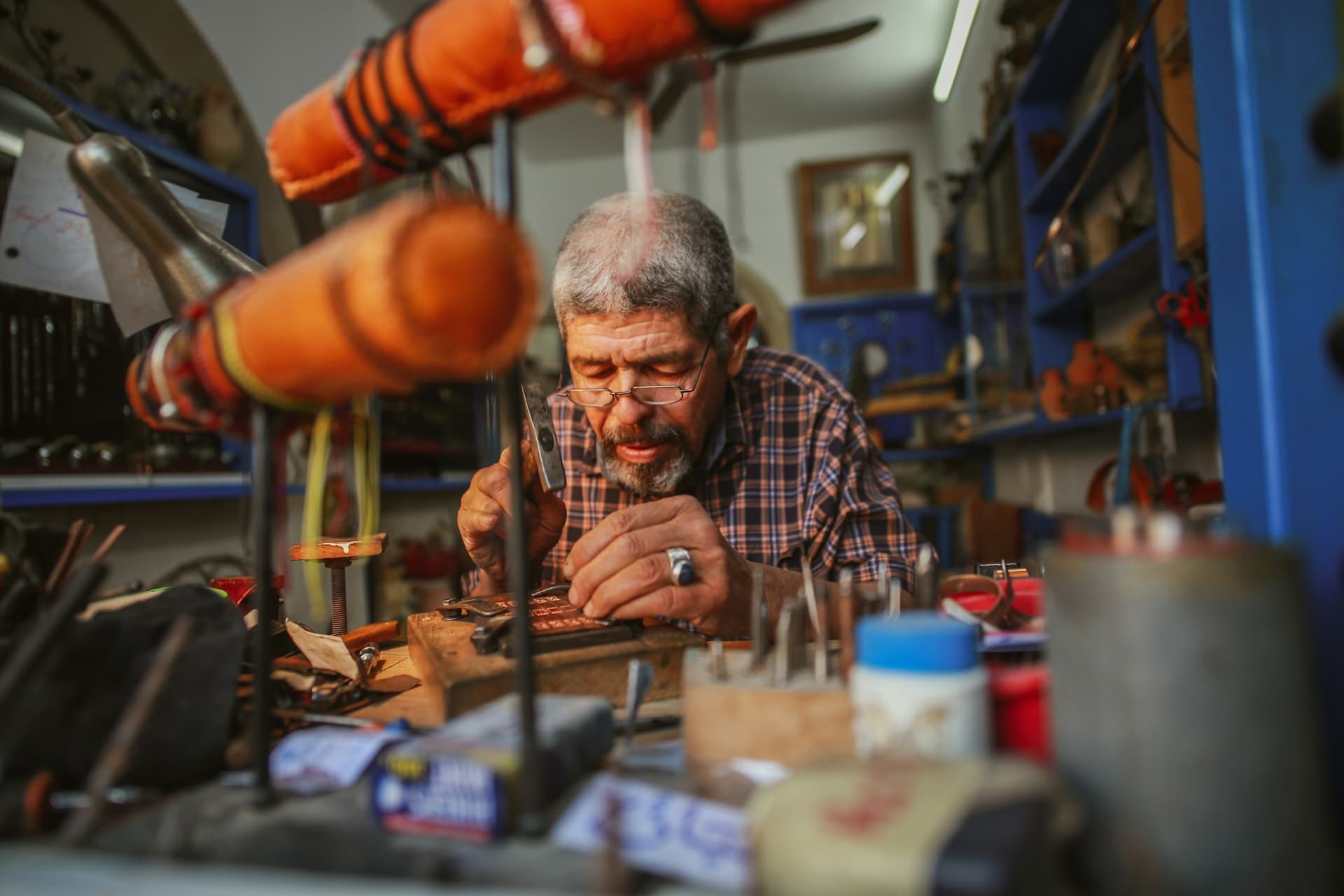 A man concentrating on a craft project in a workshop